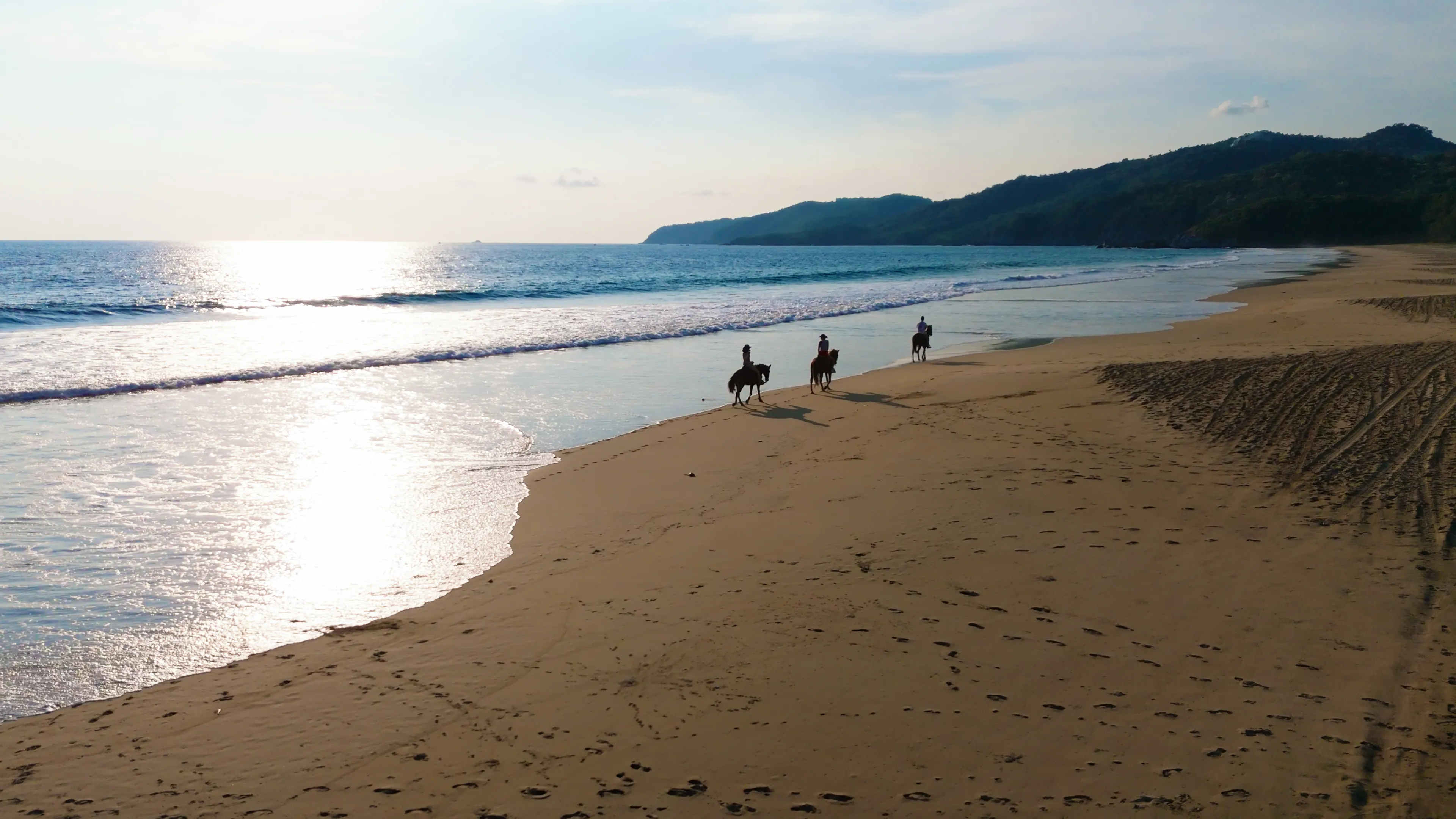 Horseback riding along Playa Larga at sunset